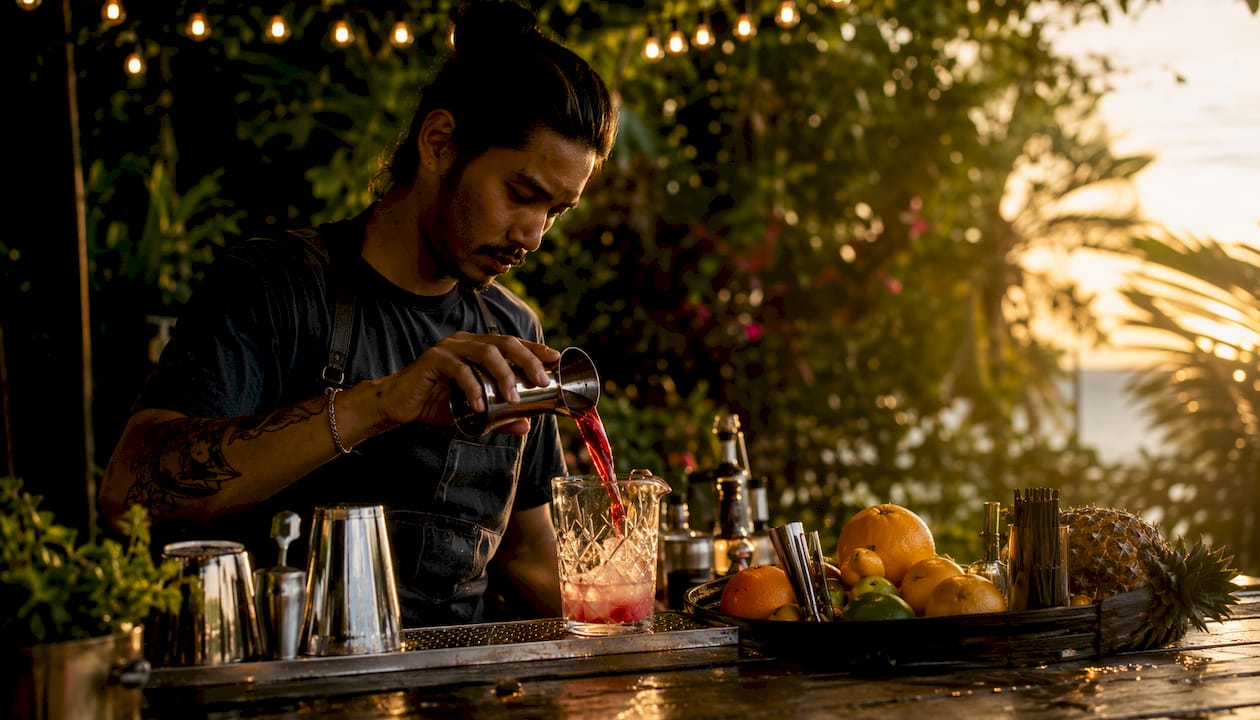 Bartender mixing cocktail at reception bar
