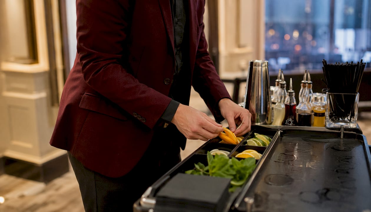 Mobile bartender preparing garnishes outdoors in evening