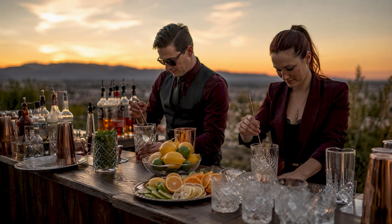 Outdoor wedding bar setup with bartenders serving guests