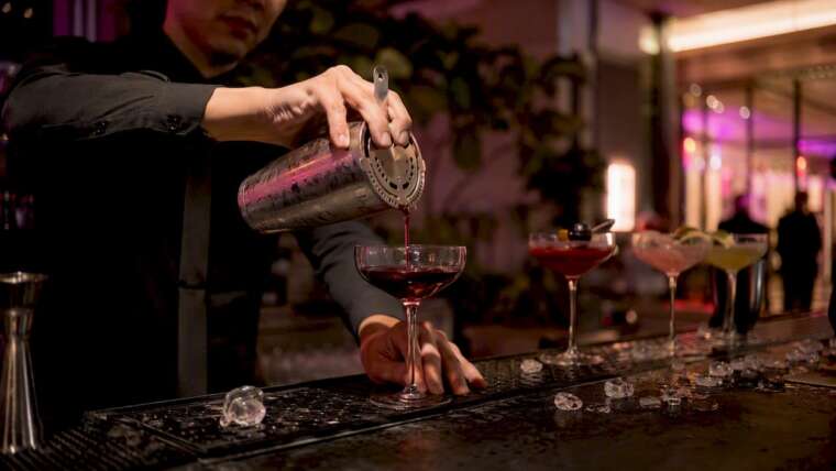 Bartender pouring signature cocktail at mobile bar