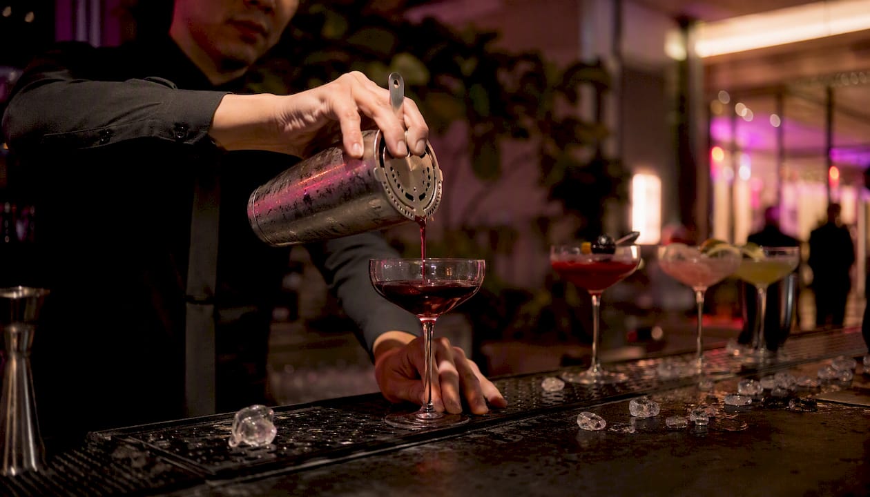 Bartender pouring signature cocktail at mobile bar