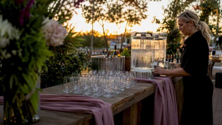 Shaded outdoor wedding bar with stemless glasses