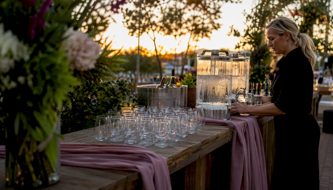 Shaded outdoor wedding bar with stemless glasses