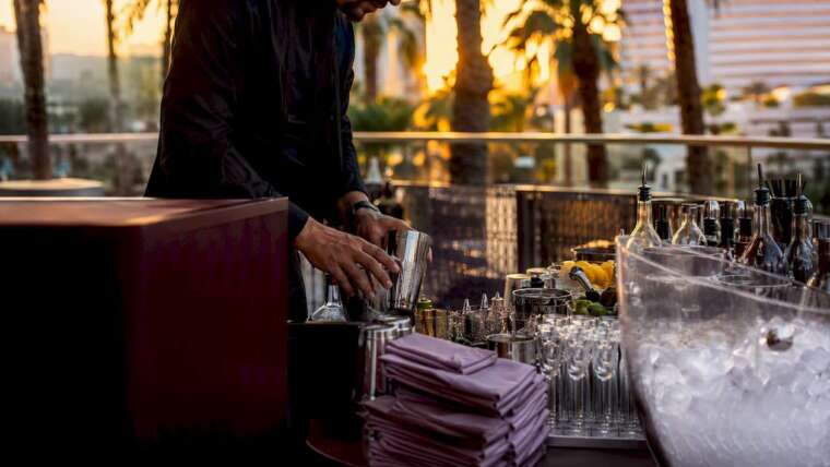 Bartender setting up glassware on mobile bar