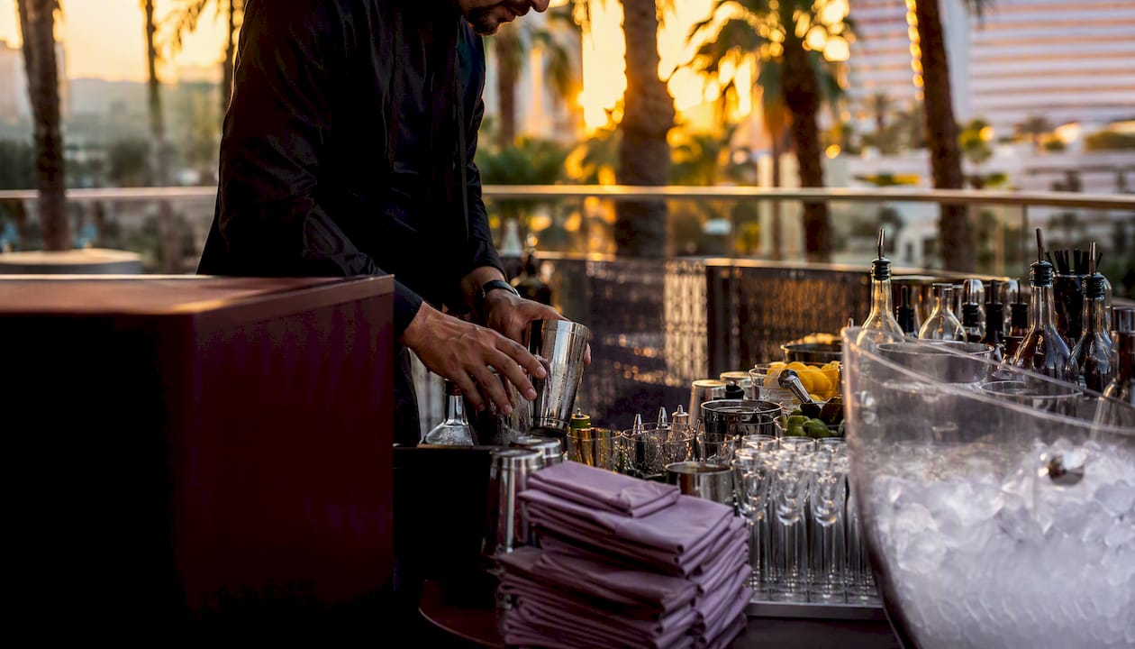 Bartender setting up glassware on mobile bar