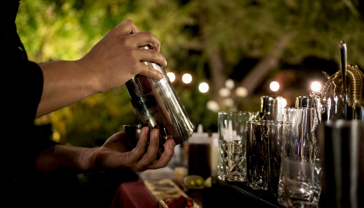 Bartender shaking cocktail at wedding bar