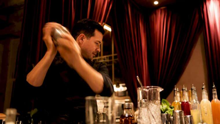 Bartender shaking cocktail at mobile bar station