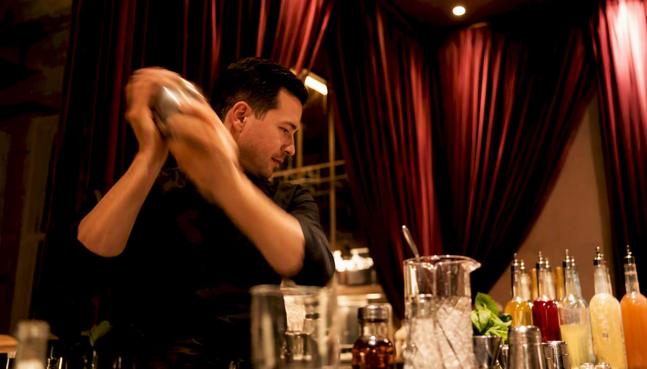 Bartender shaking cocktail at mobile bar station