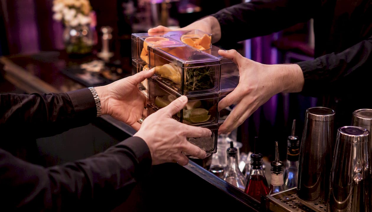 Bartender restocking cocktail station ingredients