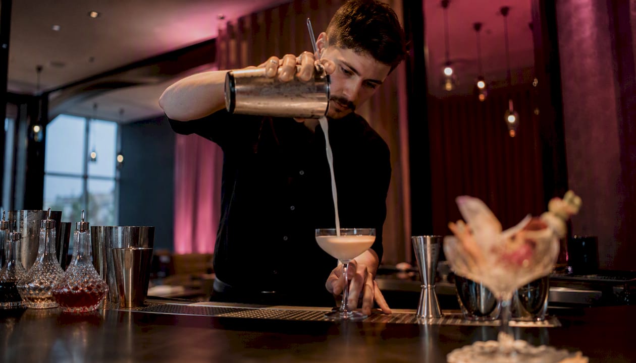 Bartender pouring cocktail at corporate bar