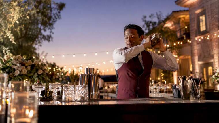 Bartender pouring cocktail at wedding bar
