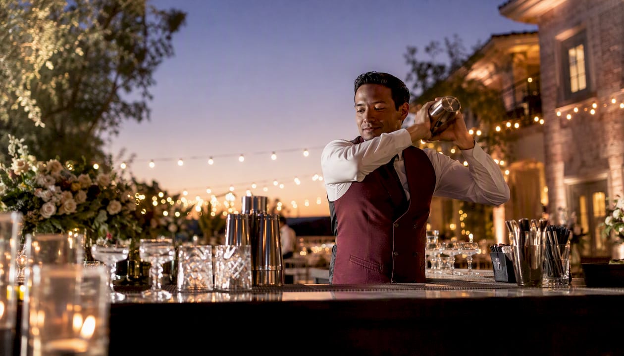 Bartender pouring cocktail at wedding bar