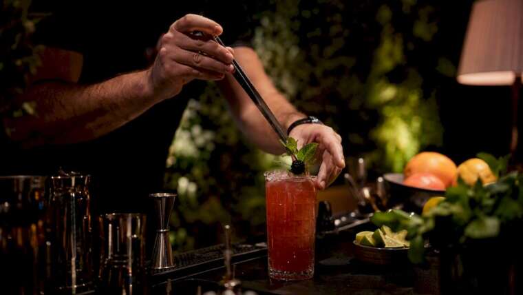 Bartender garnishing seasonal cocktail at mobile bar