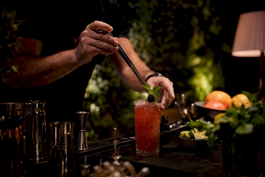 Bartender garnishing seasonal cocktail at mobile bar
