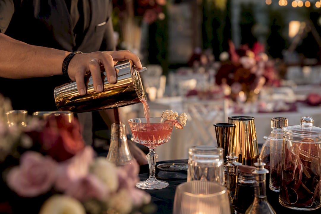 Licensed caterer pouring cocktail at event
