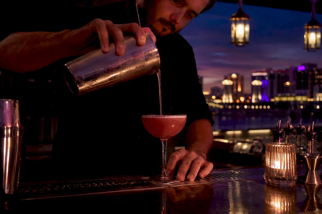 Bartender pouring cocktail at upscale event bar