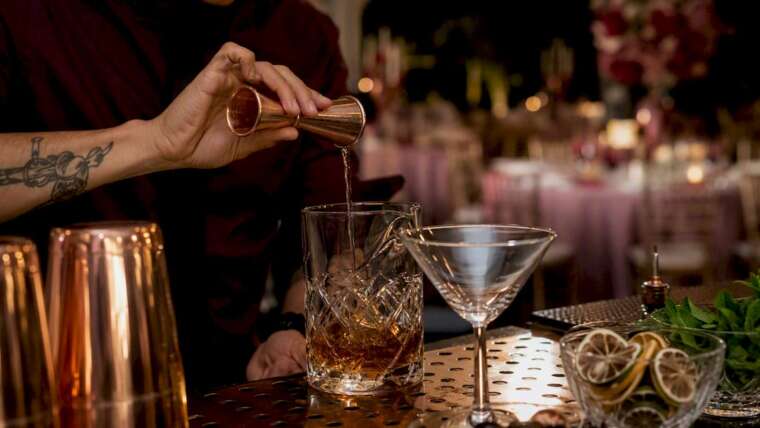 Bartender pouring cocktail measuring drink limit