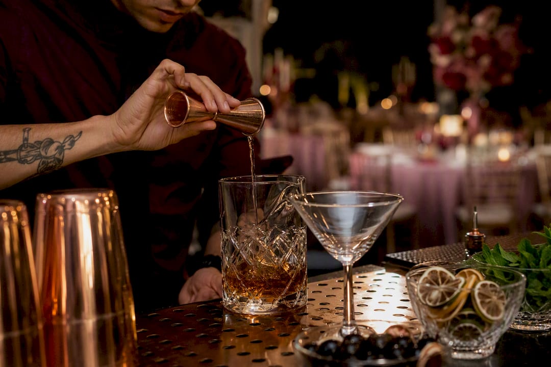 Bartender pouring cocktail measuring drink limit