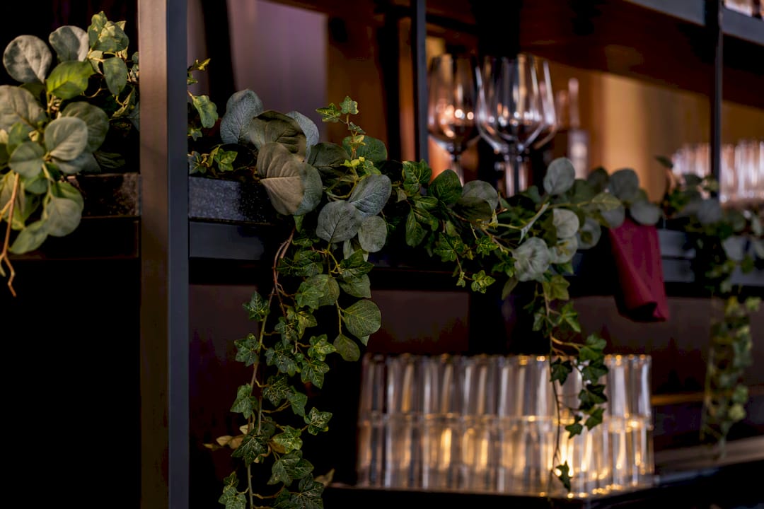 Trailing greenery softening an event bar