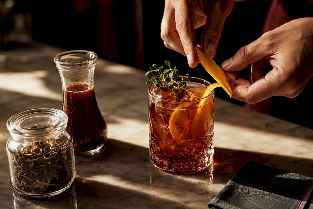 Hands garnishing a crafted alcohol-free mocktail