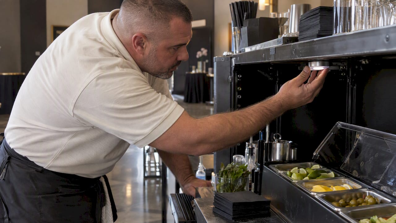 Bartender checking LED light near garnish tray