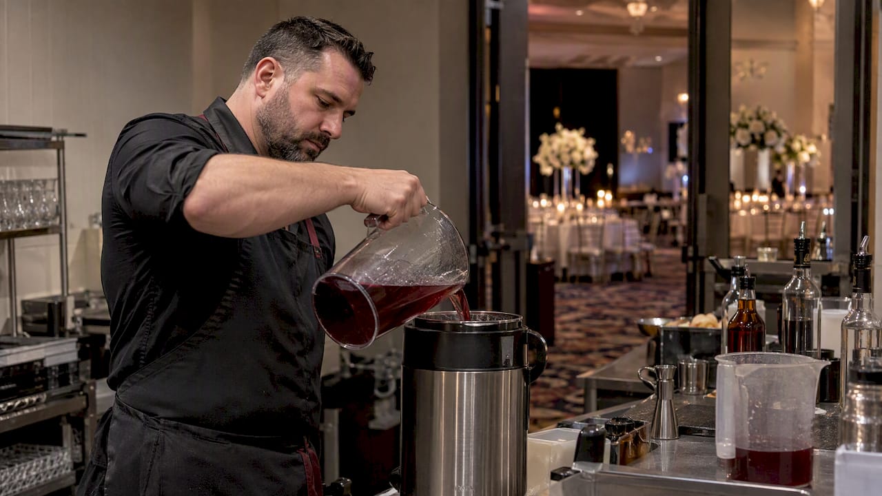 Bartender preparing a cocktail batch before an event